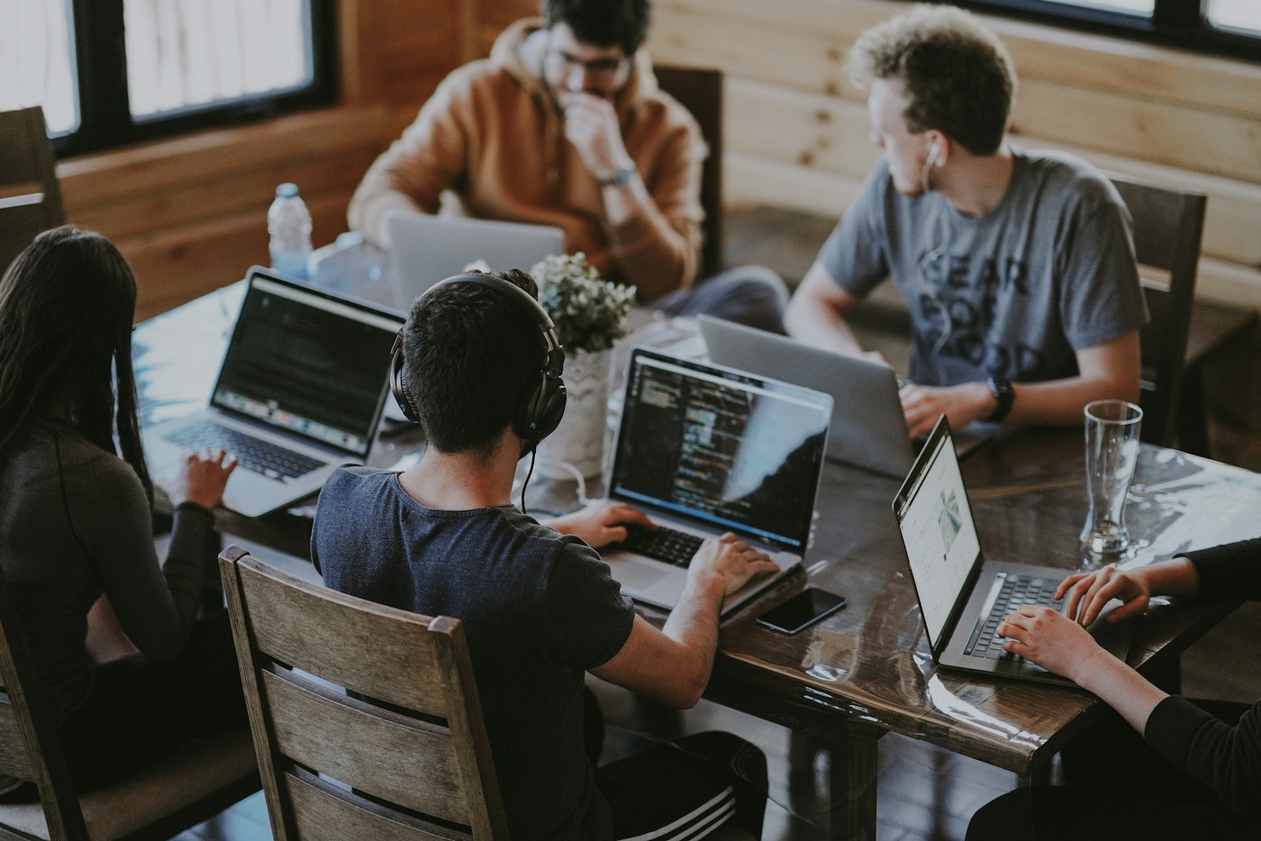People collaborating around laptops in a shared workspace